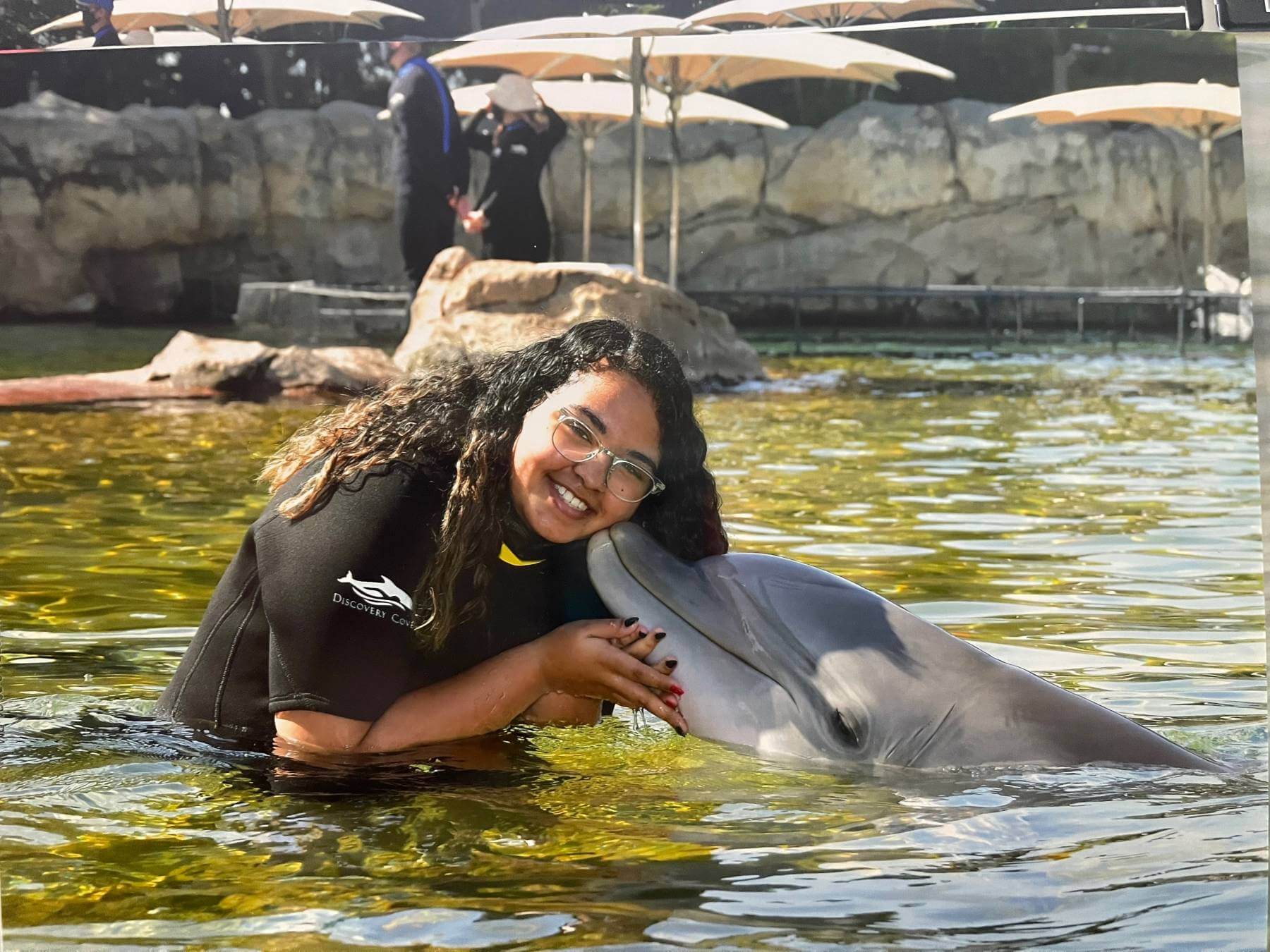 Eden being kissed by a Dolphin